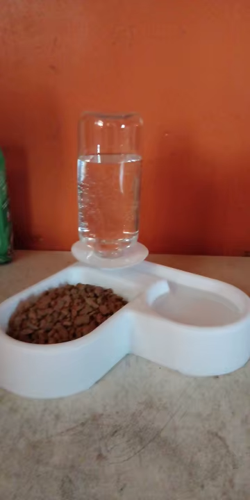 Small dog drinking from the gravity-fed pet water bowl